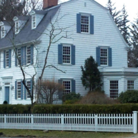 Historic colonial home with blue shutters in Ho-Ho-Kus by HS Windows.